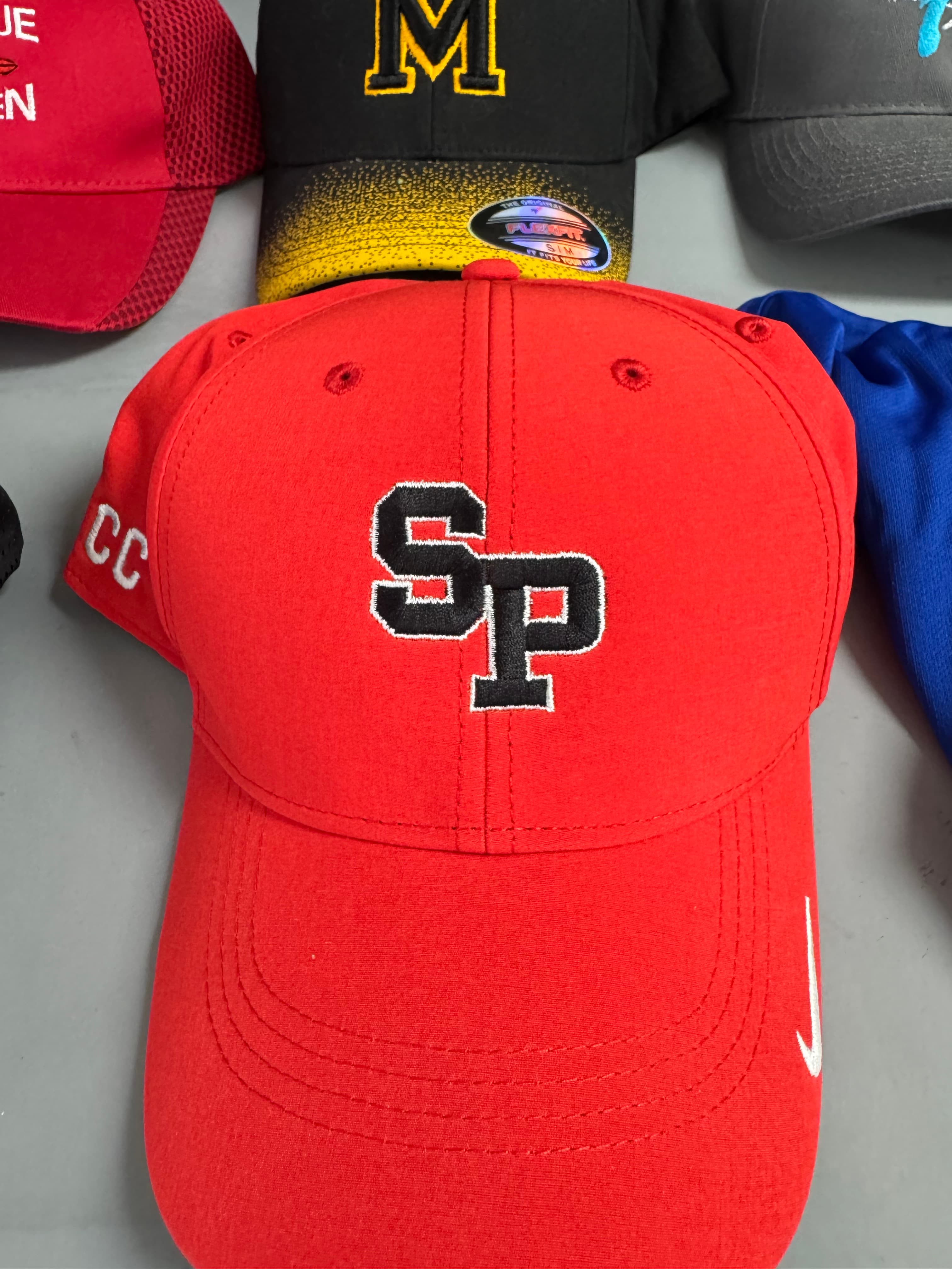 Red Nike baseball cap featuring an embroidered black and white SP logo on the front panel.
