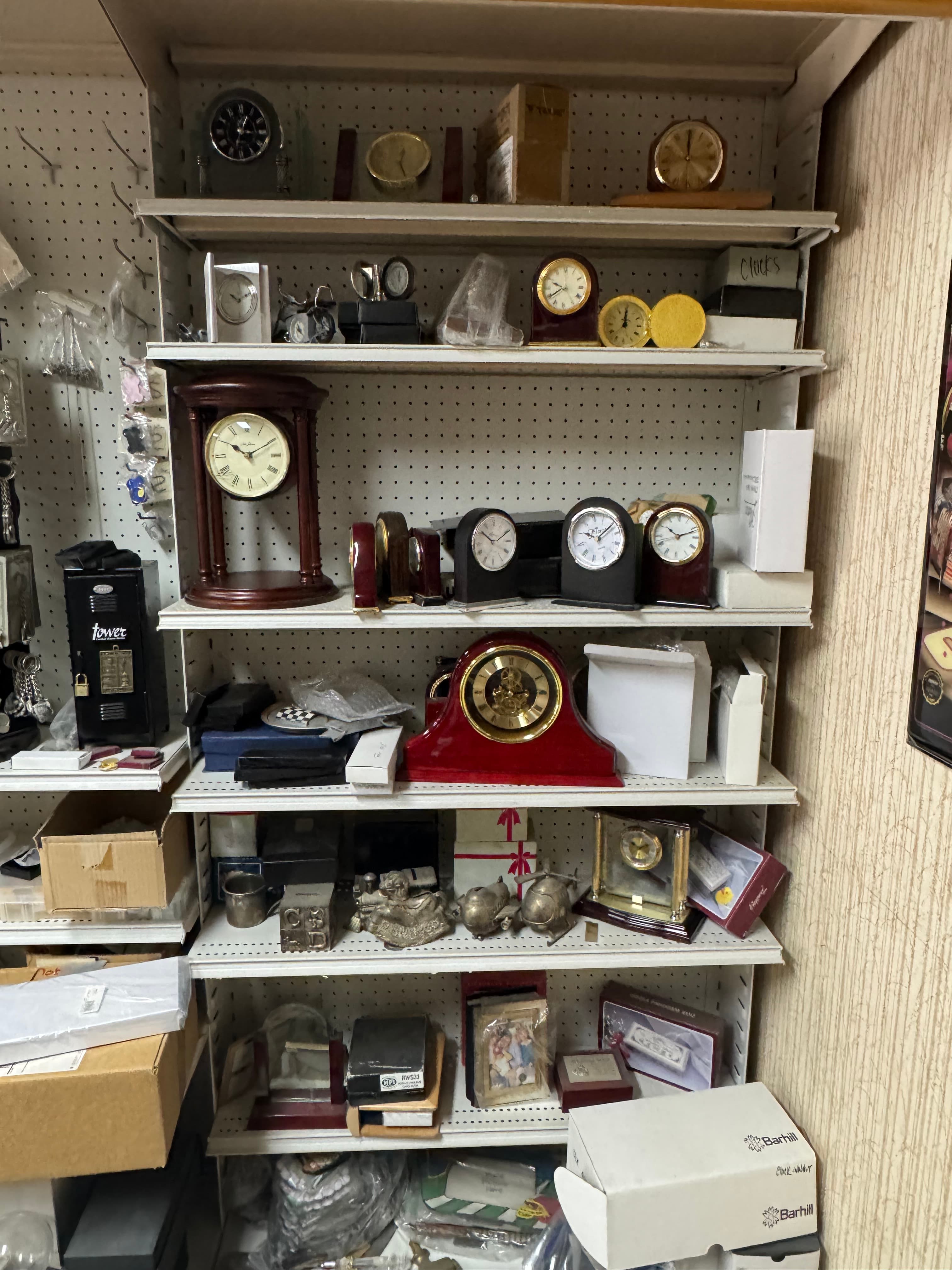 Shelves filled with various styles of mantle and desk clocks, boxes, and small decorative items.